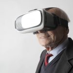 Ikääntynyt henkilö, jolla on päässä VR-lasit